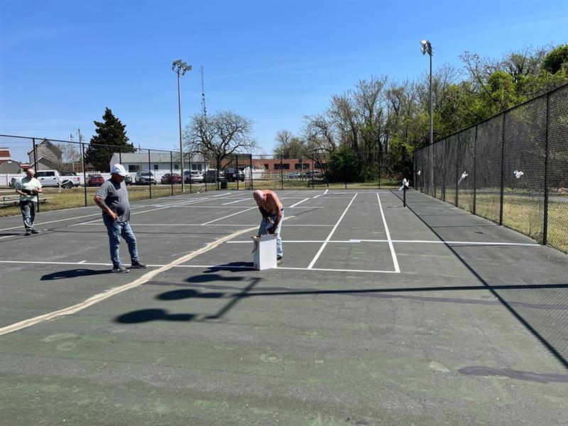 Photo of work being performed on the tennis courts